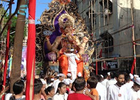 A colorful Ganesh Chaturthi procession captures the spirit of Mumbai with a large Ganesh idol surrounded by devotees.